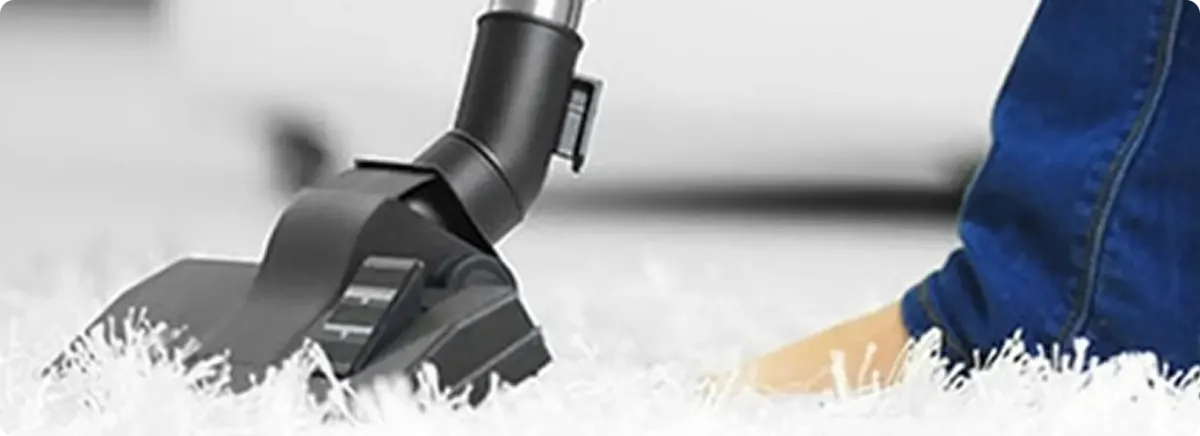 Close-up of a professional vacuuming a white carpet in Council Bluffs.